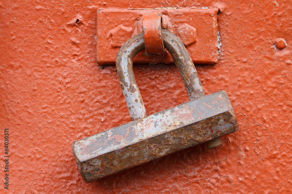 old rusty padlock on a red iron door closeup