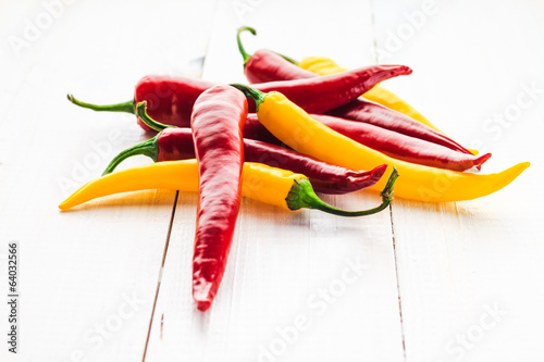 Red yellow chili peppers wooden background