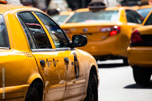 Murais de parede Yellow cab speeds through Times Square in New York, NY, USA.
