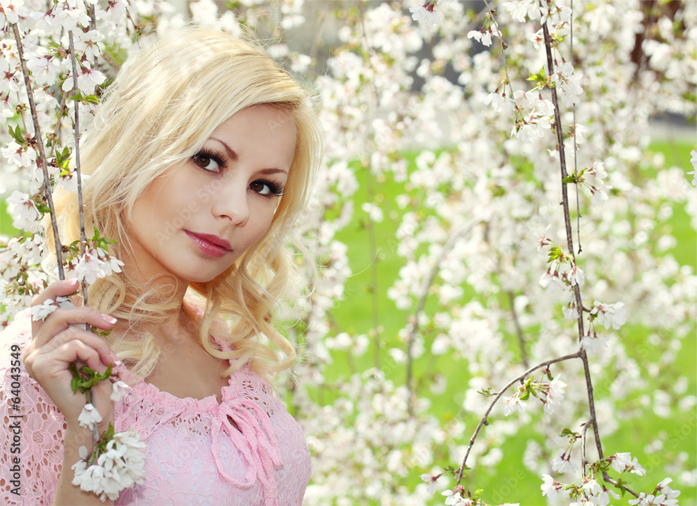 Fototapeta premium Blonde Girl with Cherry Blossom. Spring