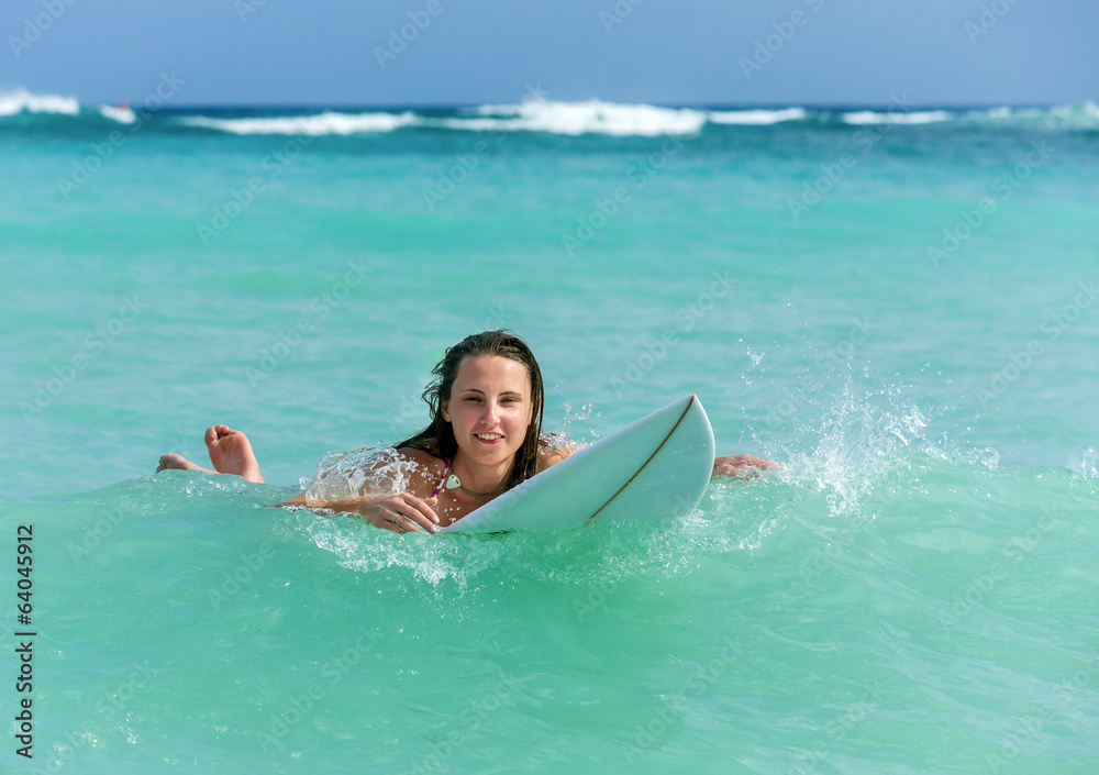 Attractive Young girl on surfboard in ocean