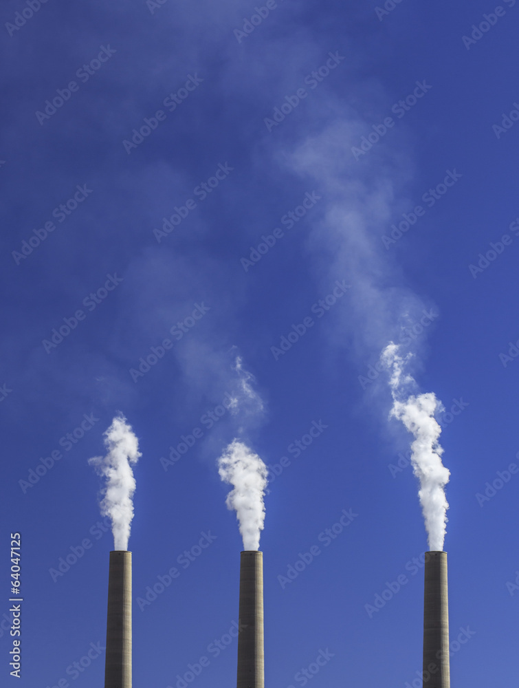 White smoke from coal powered plant stacks, profiled on sky White smoke from coal powered plant stacks, profiled on sky