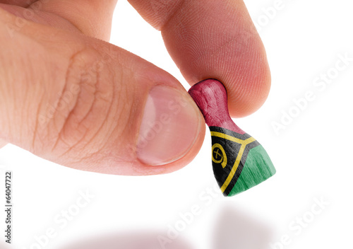 Hand holding wooden pawn, flag painting, selective focus