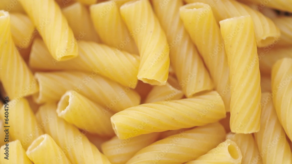 Loop able background of uncooked Italian macaroni pasta. Loop able background of uncooked Italian macaroni pasta.