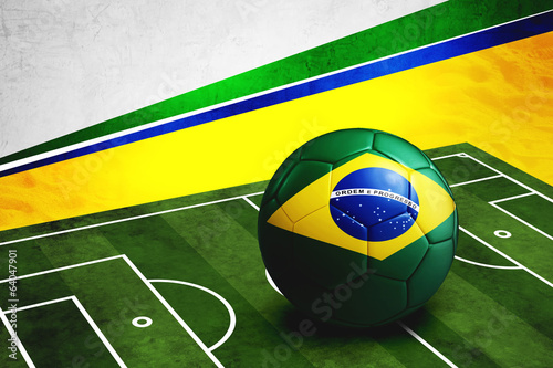 Soccer ball with Brazil flag on pitch