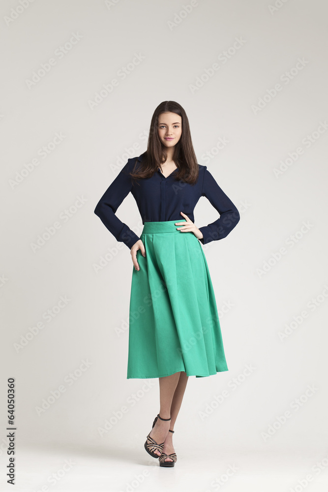 Young lady in dress posing on grey background. serios Young lady in dress posing on grey background. serios