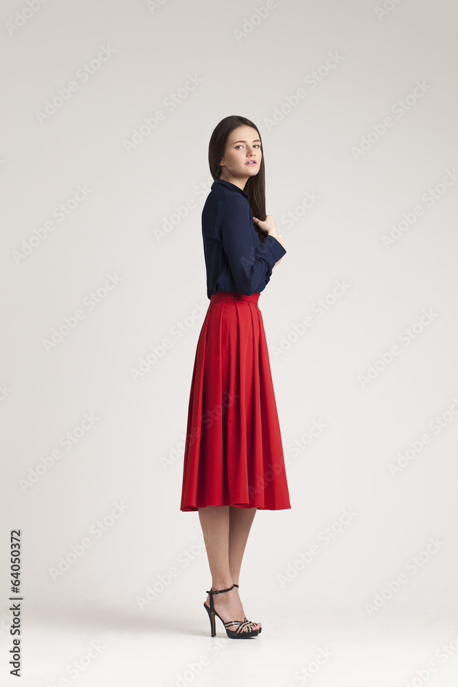 Young lady in dress posing on grey background. red Young lady in dress posing on grey background. red