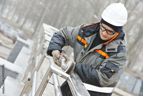 Canvastavla worker polishing metal fence barrier