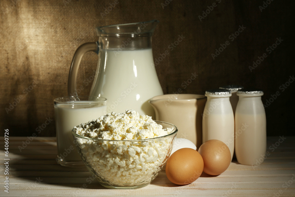 Tasty dairy products on wooden table, on sacking background Tasty dairy products on wooden table, on sacking background