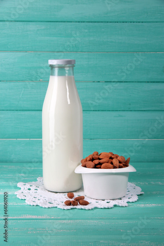 Almond milk in bottle with almonds in bowl 