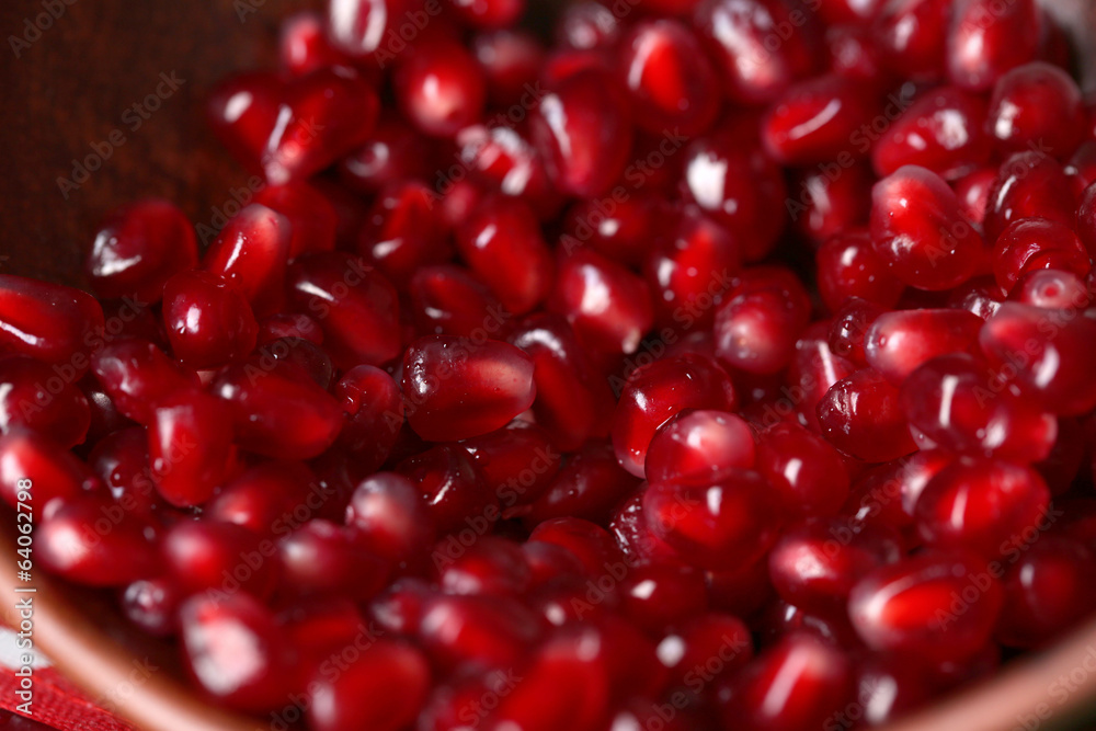 Ripe pomegranate seeds in bowl on color wooden background Ripe pomegranate seeds in bowl on color wooden background