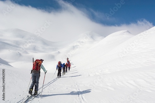 Fotótapéta Skiers walking towards mountains