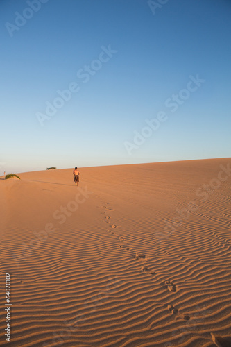 Man walking in sand dunes in La Guajira, Colombia