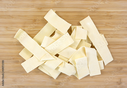 Wide egg noodles on cutting board