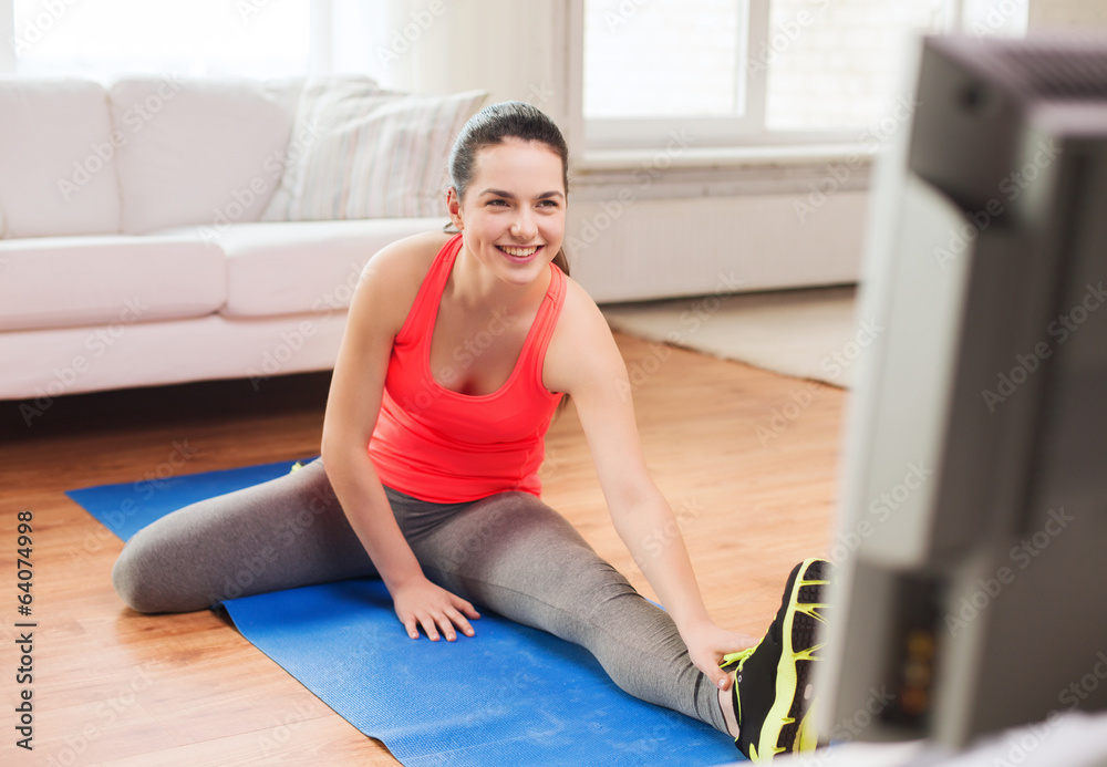 smiling teenage girl streching on floor at home smiling teenage girl streching on floor at home
