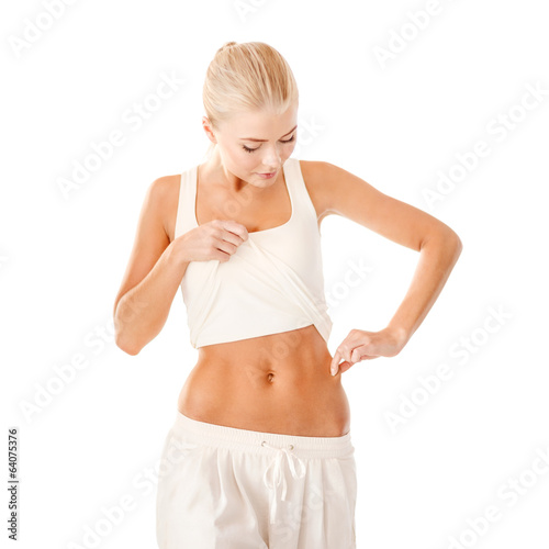 fit woman measuring fat level on her waist