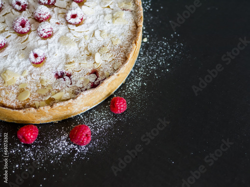 Mascarpone pie with fresh raspberries, almond and sugar powder o photo
