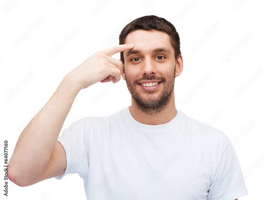 smiling young handsome man pointing to forehead smiling young handsome man pointing to forehead
