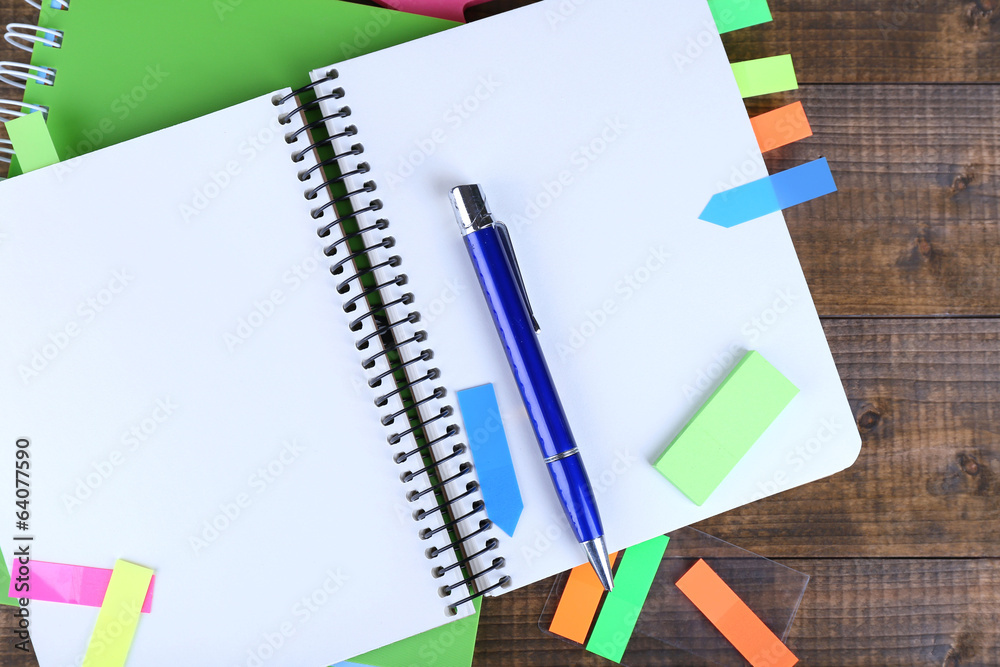 Notebook, pen, and stickers on wooden background Notebook, pen, and stickers on wooden background