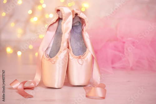 Ballet pointe shoes on floor on bokeh background