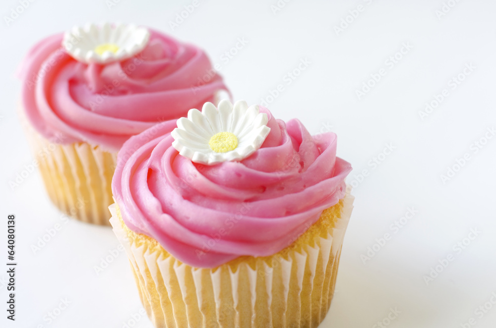 Two pink cupcakes with daisy flower decoration Two pink cupcakes with daisy flower decoration