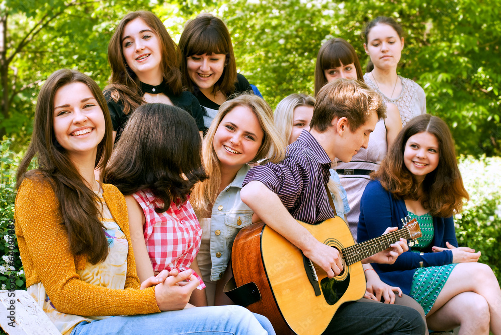 Obraz premium Teen boy singin by guitar for girls