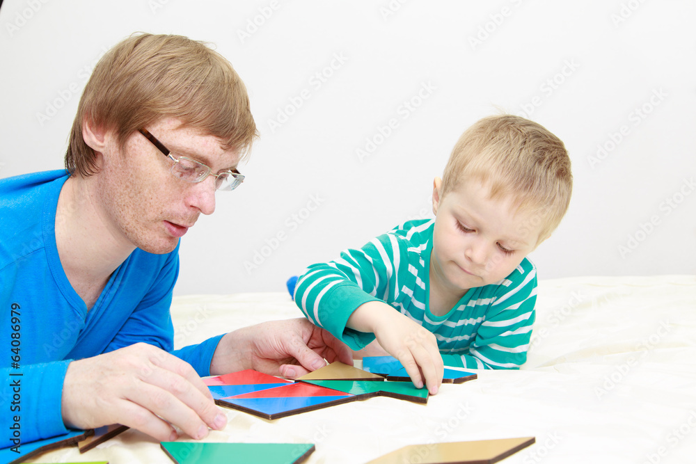 father and son playing with puzzle father and son playing with puzzle