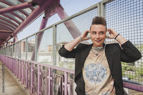 Pretty short hair girl listening to music on a bridge photo