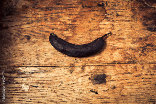 Black banana on a wooden table