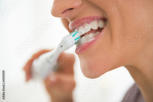 Closeup on young woman brushing teeth photo