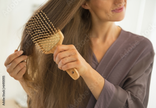 Closeup on young woman combing hair photo