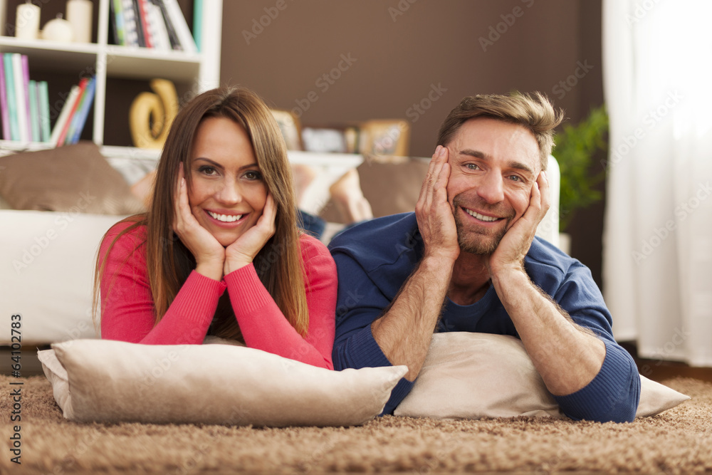 Happy couple relaxing on carpet at home Happy couple relaxing on carpet at home