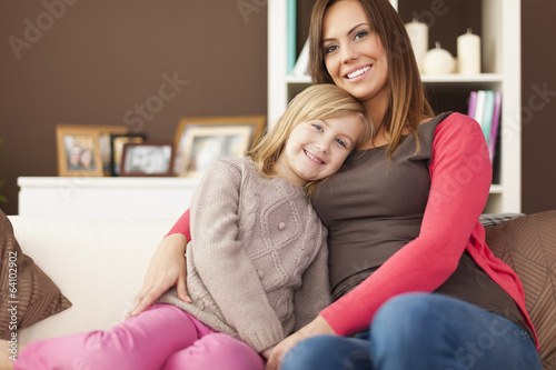 Portrait of loving mother with daughter on sofa