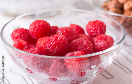 raspberries and hazelnuts in glass bowls