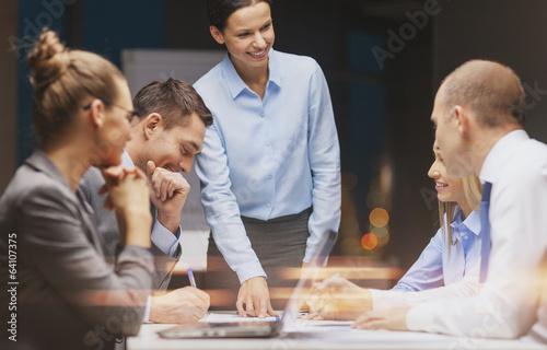 smiling female boss talking to business team photo