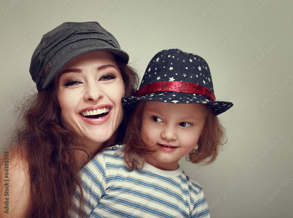 Fashion smiling family in caps. Laughing mother and kid girl Fashion smiling family in caps. Laughing mother and kid girl