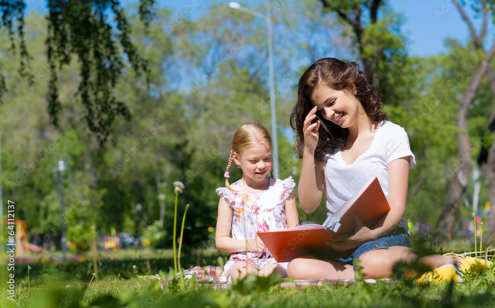 girl and a young woman reading a book together