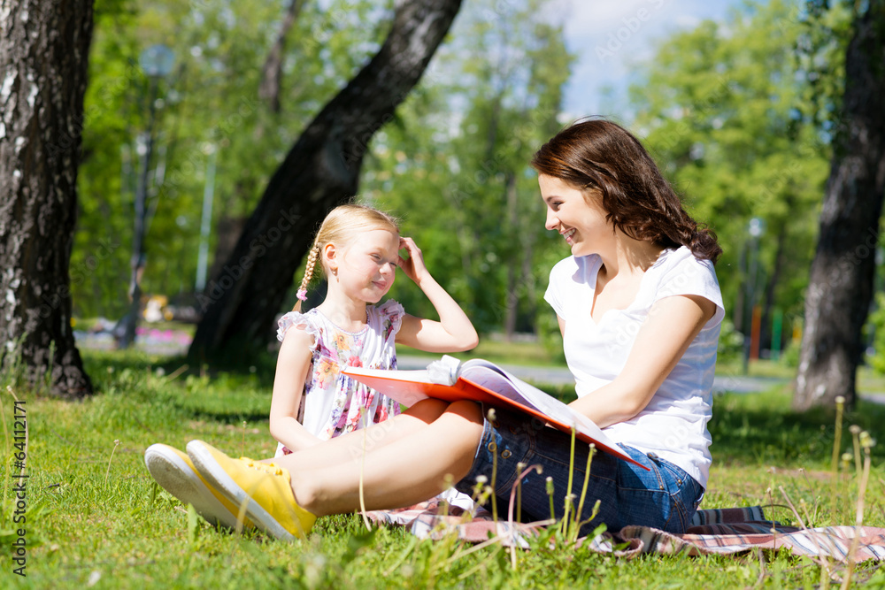 girl and a young woman reading a book together girl and a young woman reading a book together