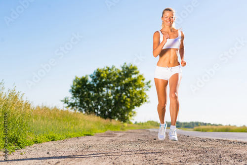 young athletic woman running on the road