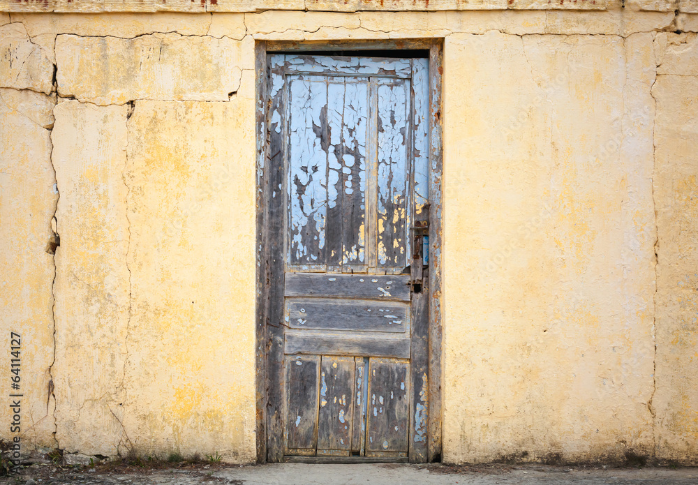 Old wooden door in yellow wall. Background photo texture Old wooden door in yellow wall. Background photo texture