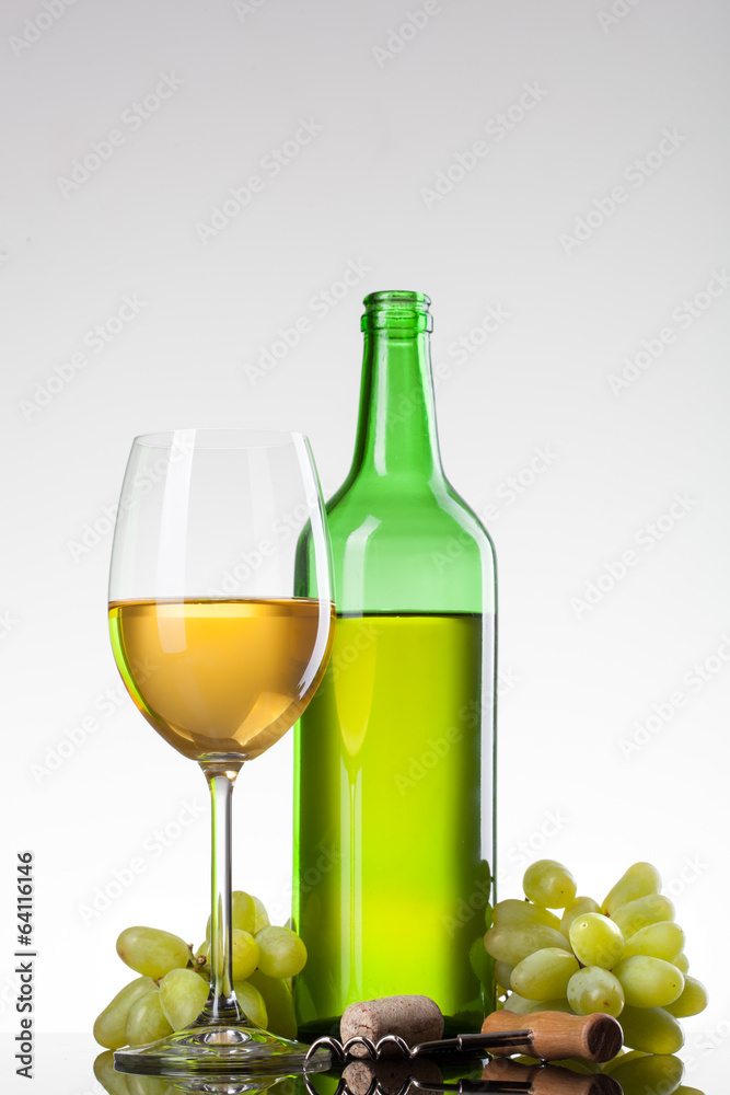 White wine in glass with grape and bottle