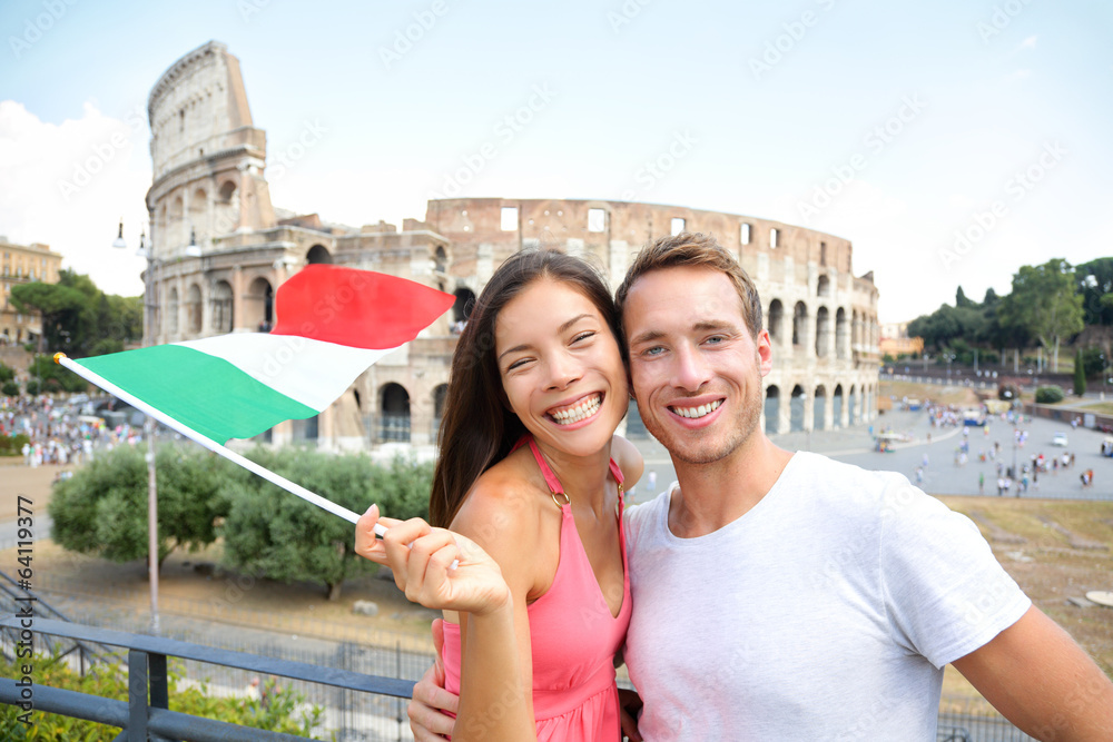 Italy travel couple with Italian flag by Colosseum