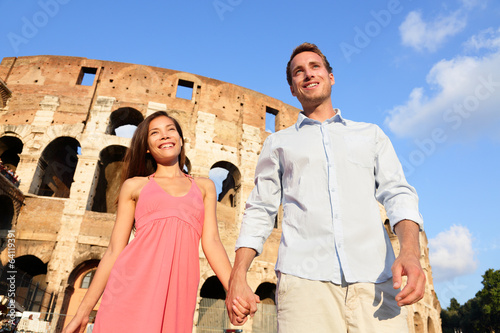Photography Couple in Rome by Colosseum walking holding hands