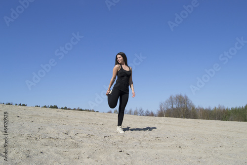 Woman stretching / working out at the beach (sunny day)
