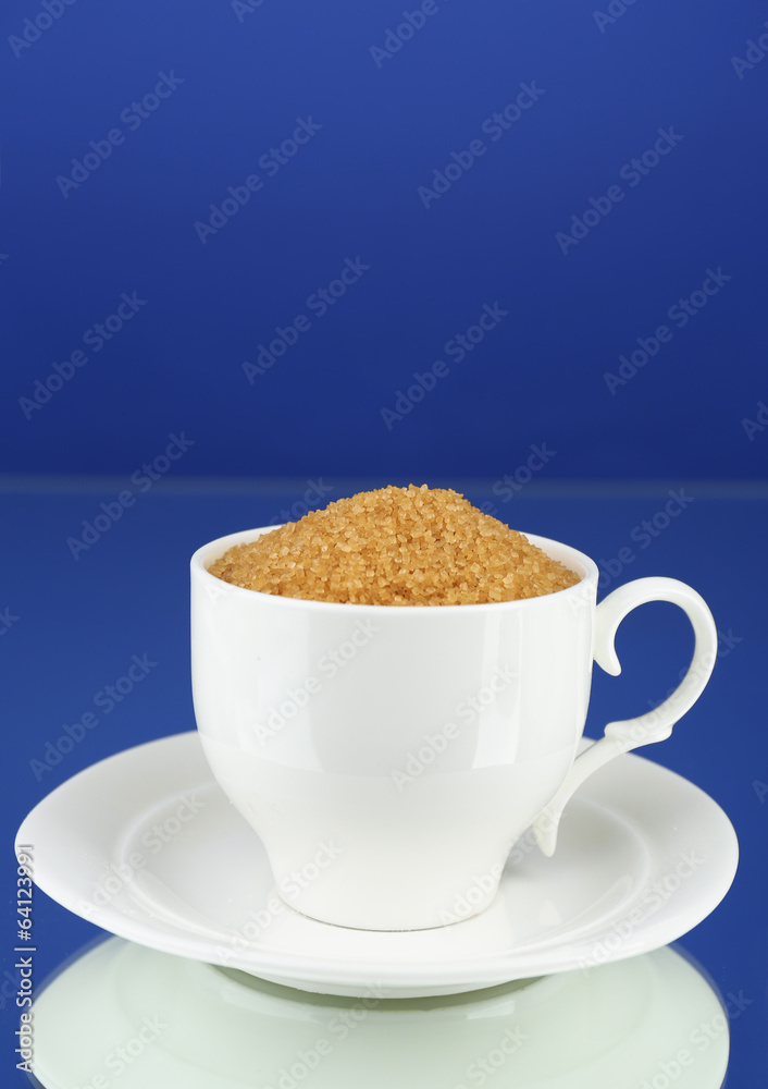 Sugar in cup on blue background Sugar in cup on blue background