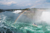 Beautiful rainbow forming near tourist boat at Niagara Falls, On