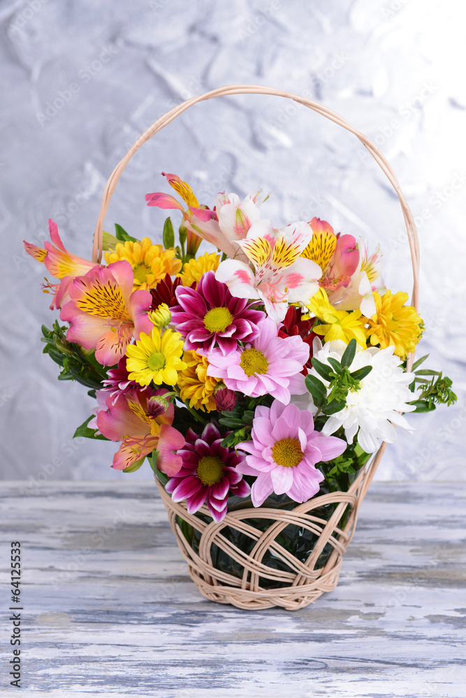 Beautiful bouquet of bright flowers in wicker basket