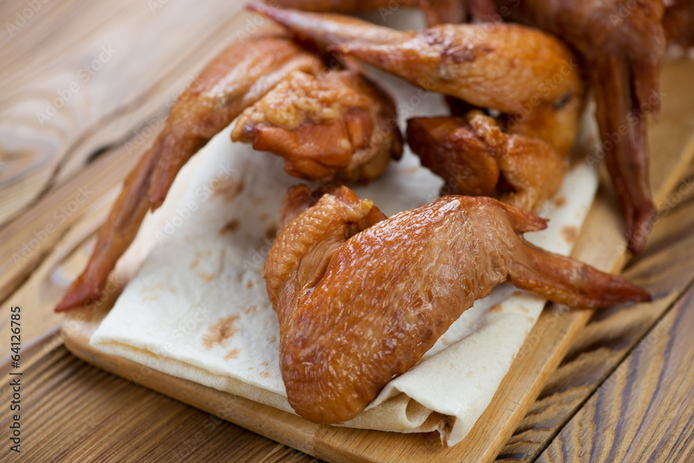 Close-up of smoked chicken wings on pita bread, studio shot