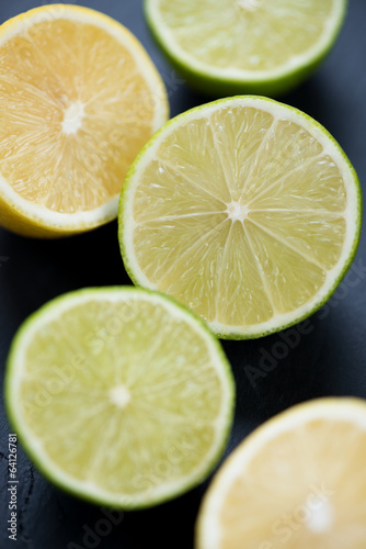 Close-up of sliced limes and lemons over black background