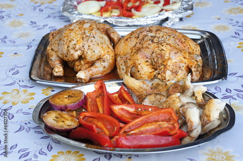 Two chicken roasted on grill with garnish photo